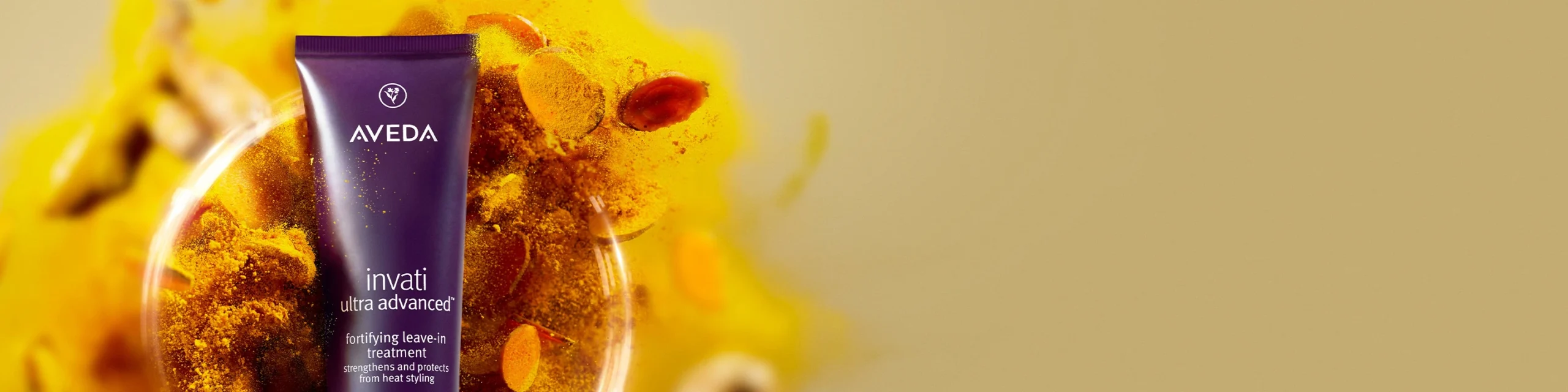 Aveda Invati Advanced tube displayed in front of a bowl with yellow and orange powder, set against a plain light background at Salon Dulay, Orlando, FL. - Salon Dulay, FL